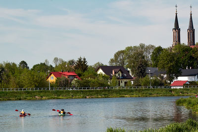 People in lake against sky