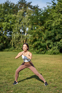 Young woman exercising on field