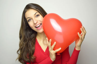 Portrait of a smiling young woman against gray background