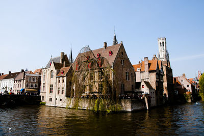 Canal amidst buildings against clear sky