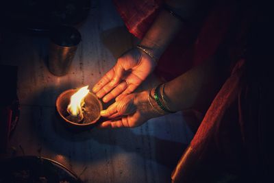 Close-up of hand holding burning candles