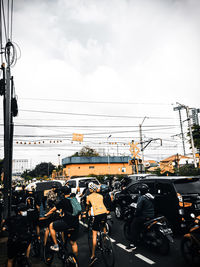 Vehicles on road in city against sky