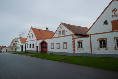 Houses by street against sky in city