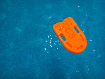 High angle view of orange leaf floating on swimming pool