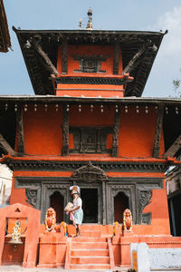 Group of people outside temple against building