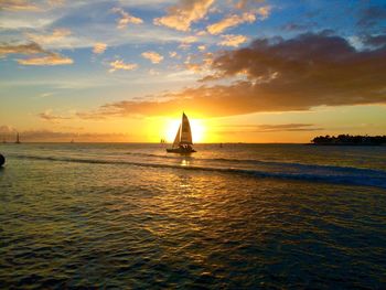 Boat sailing in sea at sunset