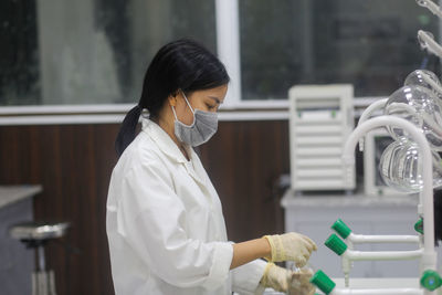 Vietnamese woman scientist washing equipment in the laboratory