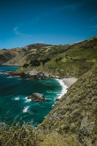 Scenic view of sea and mountains against blue sky