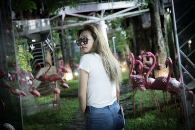 Young woman standing by plants