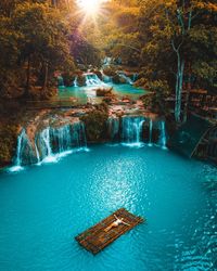 Girl lying on a bamboo raft in the middle if a waterfall in the philippines 