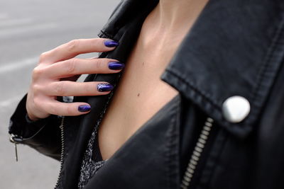 Midsection of woman wearing leather jacket