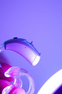 Low angle view of illuminated lighting equipment against blue background