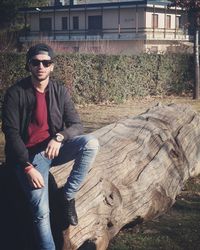 Portrait of young man sitting on wood