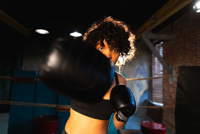 Side view of young woman exercising in gym