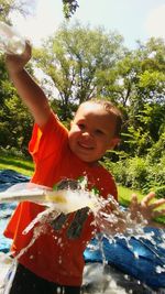 Portrait of happy boy playing in water