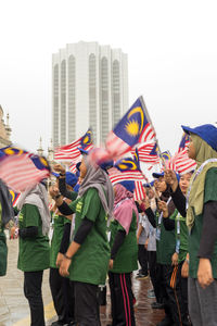 Group of people on street against buildings in city