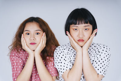 Portrait of lesbian couple against gray background