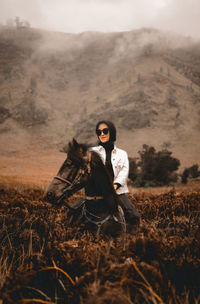 Full length of woman standing on field against sky