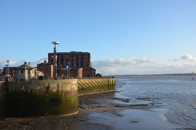 Building by sea against blue sky