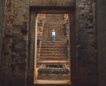 Woman standing on steps at old ruin
