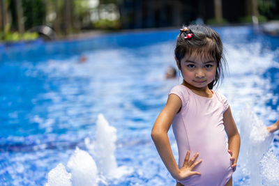 Portrait of cute girl standing in swimming pool