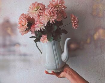 Close-up of hand holding flower vase