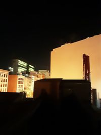 Low angle view of silhouette buildings against sky at night