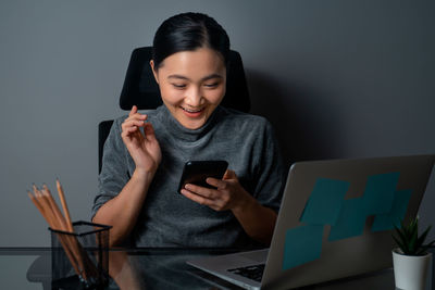 Young man using mobile phone while sitting on table
