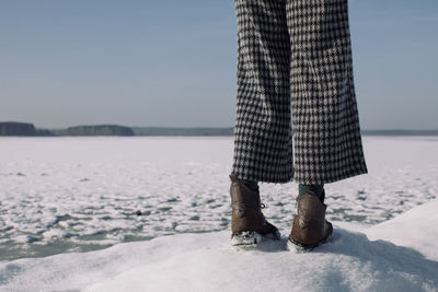 Young girl standing near frozen lake.