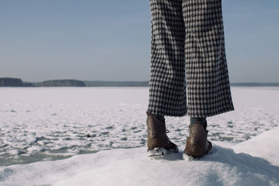 Low section of man standing on shore