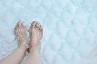 Low section of woman relaxing in swimming pool