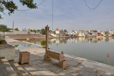 Scenic view of lake by buildings against sky