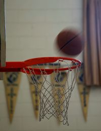 Blurred motion of ball falling in basketball hoop