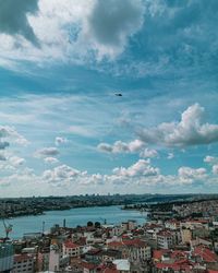 Aerial view of townscape by sea against sky