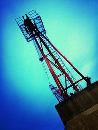 Low angle view of crane against blue sky