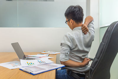 Man using mobile phone while sitting on table