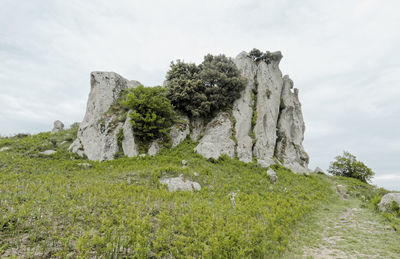 Rock formation on field against sky