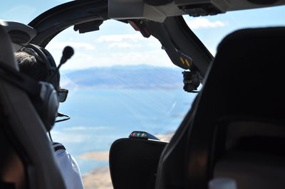 Close-up of hand on car against sky