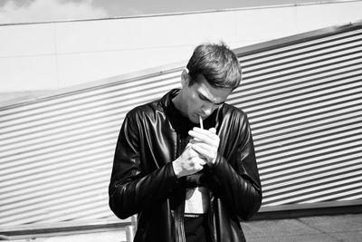 Man looking at camera while standing against wall