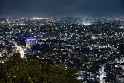 High angle view of city lit up at night