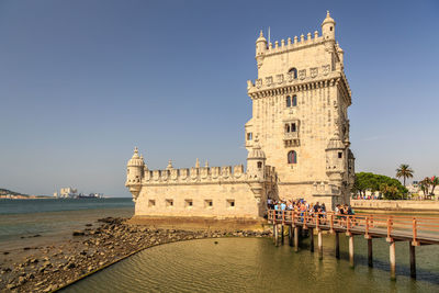 Group of people in front of historical building against sky