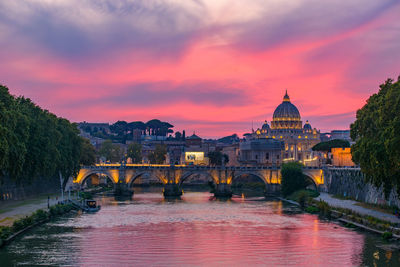 Arch bridge over river during sunset