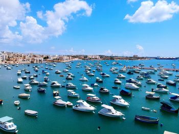 Sailboats moored on sea against sky