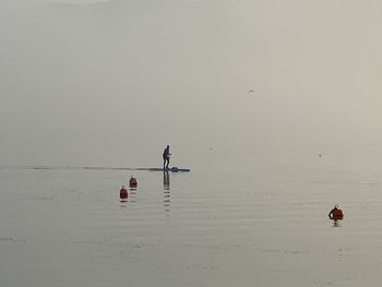 People on sea against sky