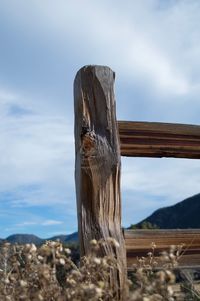 Close-up of wooden post against sky