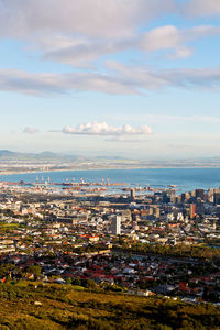 High angle view of city buildings against cloudy sky