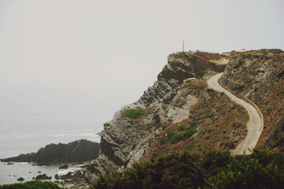 Rock formations by sea against clear sky