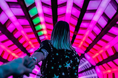 Rear view of woman standing on illuminated stage