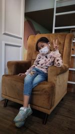 Boy sitting on sofa at home