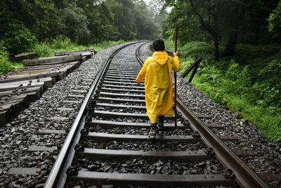 Rear view of boy standing on railroad track - dudhsagar trek